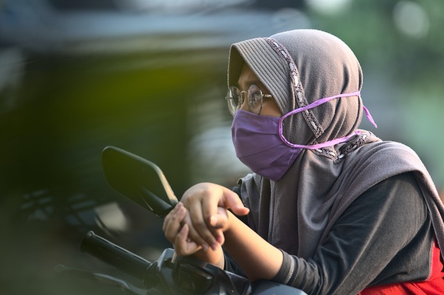 Seorang perempuan mengenakan masker sebagai salah satu protokol kesehatan. (Foto: Mufid Majnun/Unsplash)