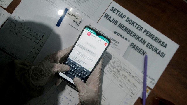 Dokter melayani konsultasi kesehatan kepada pasien peserta BPJS Kesehatan melalui aplikasi gawai mobile JKN di Klinik Mutiara Medika, Lebak, Banten. Foto: Muhammad Bagus Khoirunas/ANTARA FOTO