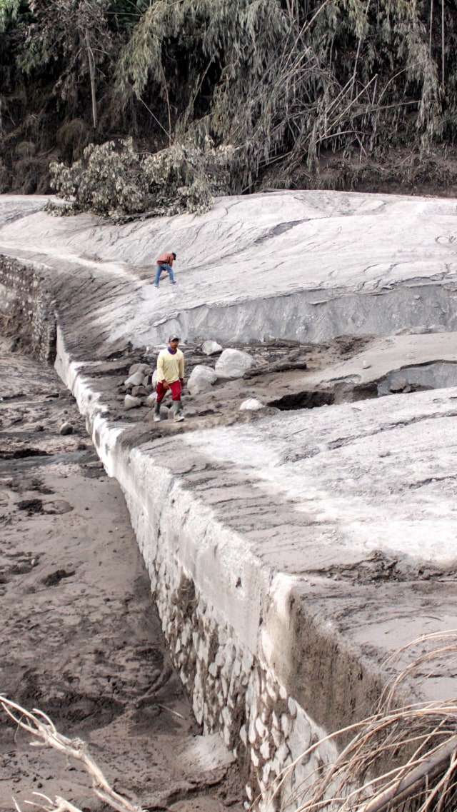 Warga berjalan di samping jalur lahar panas Gunung Semeru di kawasan Pronojiwo, Lumajang, Jawa Timur, Rabu (2/12). Foto: Umarul Faruq/ANTARA FOTO