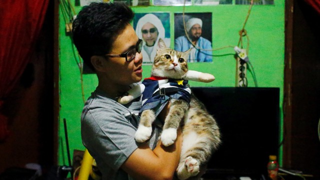 Risma Sandra Irawan, 31 tahun, menggendong kucingnya dengan kostum cosplay, di Jakarta Foto: Ajeng Dinar Ulfiana/REUTERS