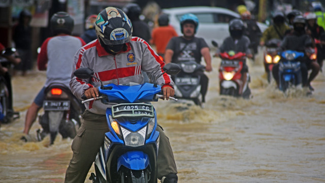 Sejumlah pengendara sepeda motor terjebak banjir saat melintas di Kampung Karundang, Cipocok, Serang, Banten, Kamis (3/12). Foto: Asep Fathulrahman/ANTARA FOTO