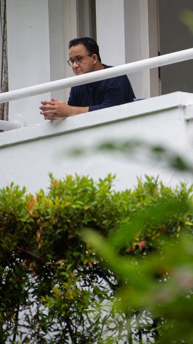 Gubernur DKI Jakarta Anies Baswedan mengamati suasana luar ruang saat menjalani isolasi di rumah dinasnya di Menteng, Jakarta Pusat, Kamis (3/12). Foto: Aditya Pradana Putra/ANTARA FOTO