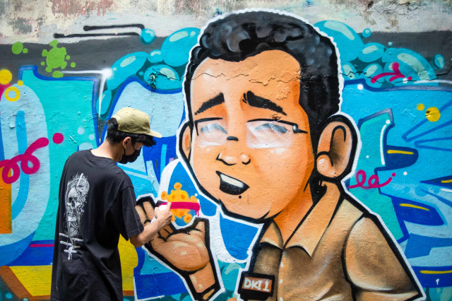 Seniman grafiti dari komunitas Eter Room melukis karya mereka yang berjudul 'Tumbang' pada dinding salah satu bangunan di Cikini, Jakarta, Kamis (3/12/2020).  Foto: Aditya Pradana Putra/ANTARA FOTO