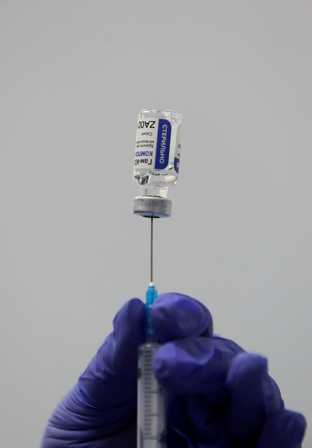 Seorang petugas medis mengisi jarum suntik dengan vaksin Sputnik V. Foto: Maxim Shemetov/REUTERS
