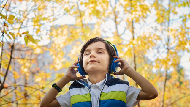 seorang anak kecil yang sedang mendngarkan lagu dan merasakan ketenangan dalam dirinya saat mendengar lagu. Foto : Liputan6