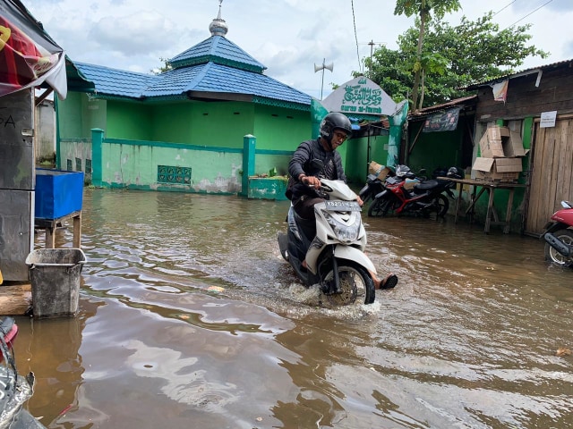 Pengunjung pasar Kapuas Indah melewati genangan. Foto: Dok. Teri/Hi Pontianak.