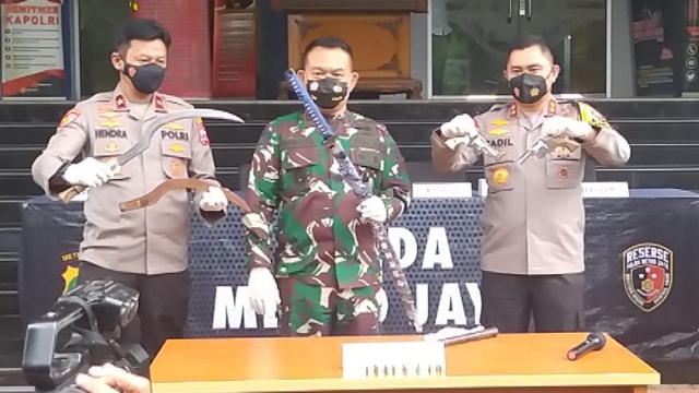 Polisi menunjukkan barang bukti senjata tajam dan senpi milik laskar khusus FPI saat konferensi pers.  Foto: Dok. Istimewa