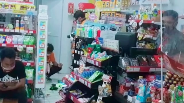 Petugas kepolisian tengah olah TKP di minimarket yang dibobol maling.