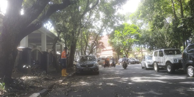 Petugas DLH Kota Malang membersihkan sisa-sisa dampak dari peristiwa angin kencang yang melanda Kota Malang, pada Selasa (8/12/2020). Foto: Ulul Azmy