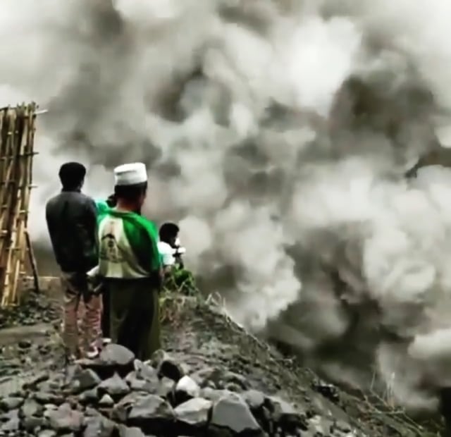 Tangkapan layar video menunjukkan warga sekitar aliran lahar Gunung Semeru menonton kepulan asap belerang di Sungai Besuk Curah Kobokan, Kabupaten Lumajang, pada Minggu (6/12/2020).