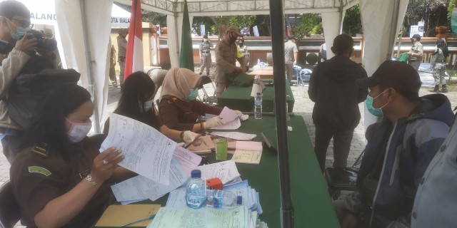 Sejumlah pelanggar protokol kesehatan di sidang di tempat di Taman Krida Budaya Jawa Timur, Kota Malang, pada Selasa (8/12/2020). Foto: Ulul Azmy