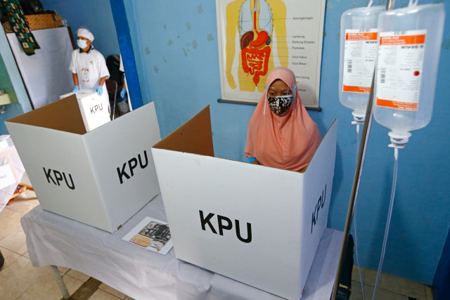 Warga menggunakan hak pilihnya di Tempat Pemungutan Suara (TPS) 56  dengan tema Rumah Sakit di Mekarjaya, Depok, Jawa Barat, Rabu (9/12). Foto: Ajeng Dinar Ulfiana/REUTERS
