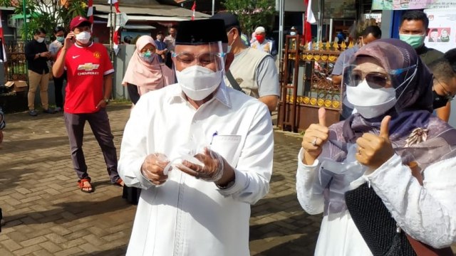 Calon Wali Kota Depok Mohammad Idris bersama istrinya saat menggunakan hak pilih di TPS 14, Depok.  Foto: kumparan