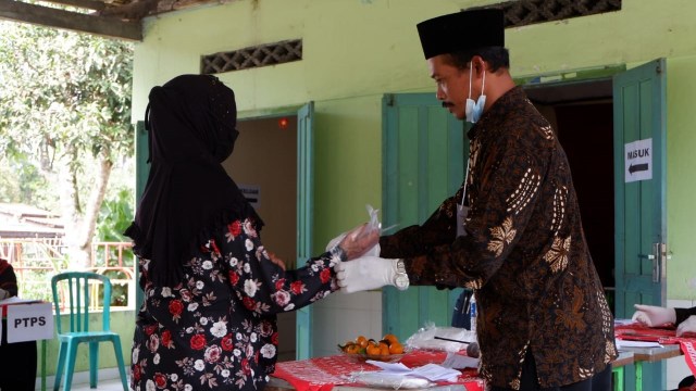 Warga memberikan hak pilihnya di Tempat Pemungutan Suara (TPS) 8 Kalitengah Lor di Barak Pengungsian Glagaharjo, Cangkringan, Sleman, DI Yogyakarta, Rabu (9/12).  Foto: Arfiansyah Panji Purnandaru/kumparan