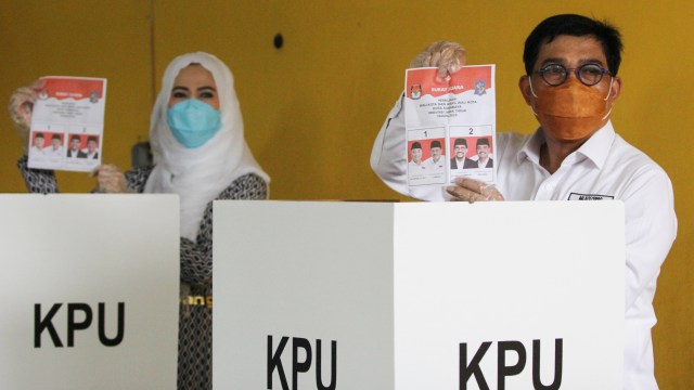 Calon Wali Kota Surabaya Machfud Arifin (kanan) bersama istri saat menggunakan hak pilihnya di TPS 25 Jalan WR Supratman, Surabaya, Jawa Timur, Rabu (9/12).  Foto: Didik Suhartono/ANTARA FOTO