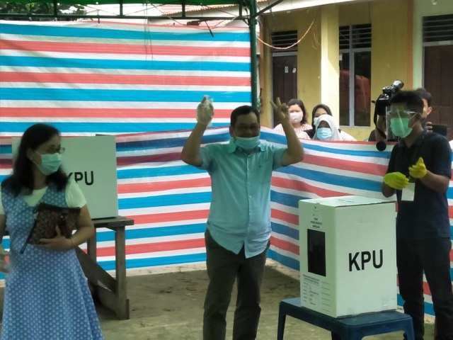 Calon Bupati Sintang nomor urut 2, Askiman menggunakan hak pilihnya di TPS. (Foto: Yusrizal/Hi! Pontianak)