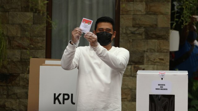 Calon Wali Kota Medan Bobby Nasution menunjukan surat suara saat menggunakan hak pilihnya pada Pilkada Kota Medan Tahun 2020 di TPS 22, Kelurahan Asam Kumbang, Medan, Sumatera Utara, Rabu (9/12).  Foto: Irsan Mulyadi/ANTARA FOTO