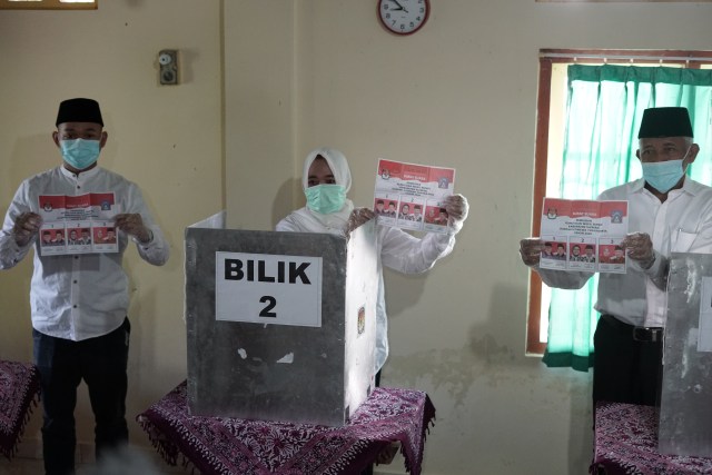Kustini Sri Purnomo (tengah) dan Sri Purnomo (kanan) menunjukkan surat suara saat pencoblosan Pilkada 2020, Rabu (9/12/2020). Foto: dok. Tim Pemenangan Kustini-Danang.