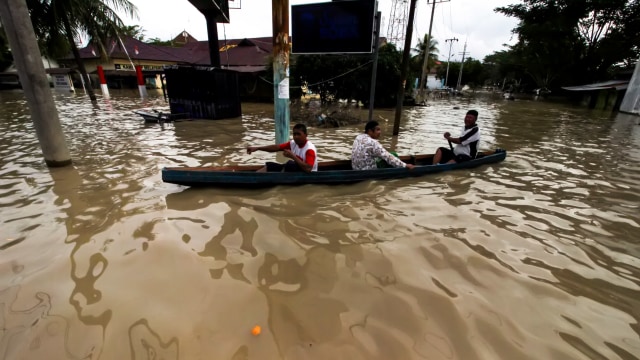 Warga menumpangi perahu keluar dari kepungan banjir yang melanda pusat ibu kota Lhoksukon, Kecamatan Lhoksukon, Aceh Utara, Aceh, Senin (7/12/2020). Foto: Rahmad/ANTARA FOTO
