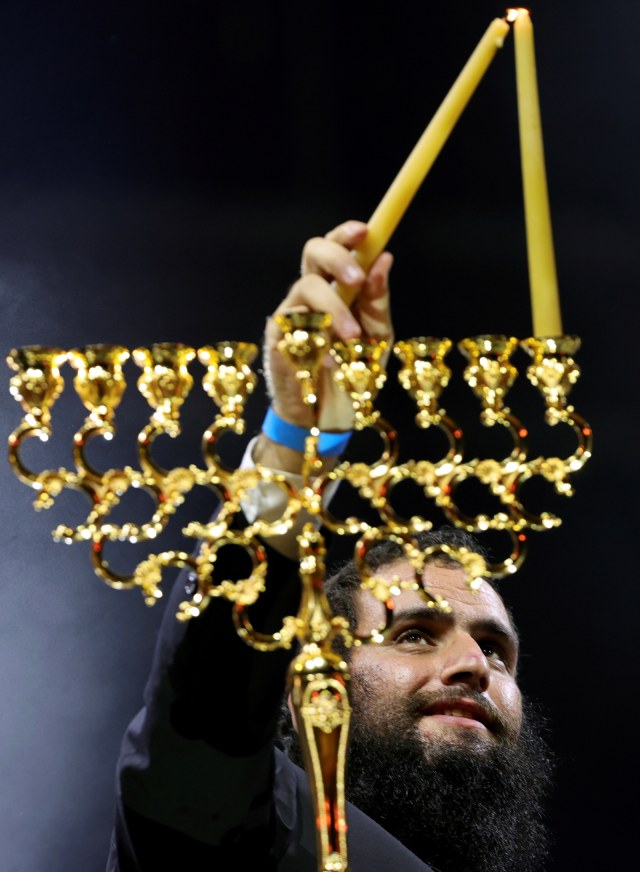 Rabbi Levi Duchman menyalakan lilin untuk merayakan Hanukkah, festival cahaya Yahudi, di Dubai, Uni Emirat Arab, Kamis (10/12). Foto: Christopher Pike/REUTERS