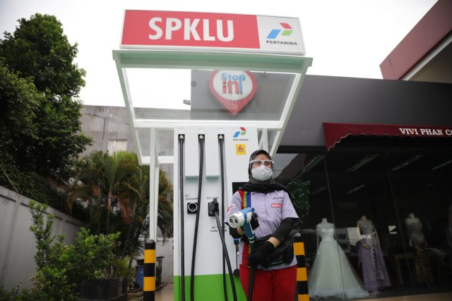 Petugas menunjukan cara pengisian daya listrik untuk kendaraan bermotor di Stasiun Pengisian Kendaraan Listrik Umum (SPKLU) komersial pertama PT Pertamina (Persero) di Fatmawati, Jakarta Selatan. Foto: Aditia Noviansyah/kumparan