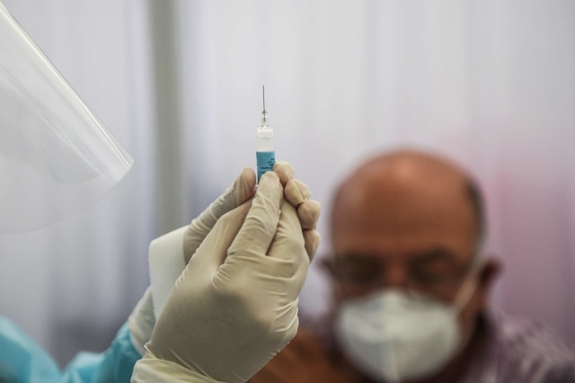 Uji coba vaksin yang diproduksi oleh Sinopharm Tiongkok di Pusat Studi Klinis Universitas Heredia Cayetano di Lima, Peru. Foto:  Ernesto Benavides/AFP
