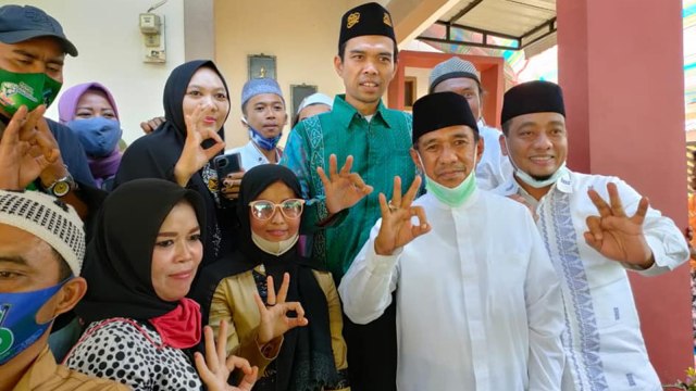 USTAD Abdul Somad mengacungkan tiga jari bersama pasangan calon Bupati-Wakil Bupati Rokan Hulu, Hafith Syukri-Erizal. 