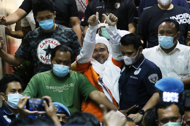 Imam Besar Front Pembela Islam (FPI) Habib Rizieq Shihab (tengah) berjalan menuju mobil tahanan usai diperiksa di Mapolda Metro Jaya, Jakarta, Minggu (13/12/2020) dini hari.
 Foto: Antara/Hafiz Mubarak