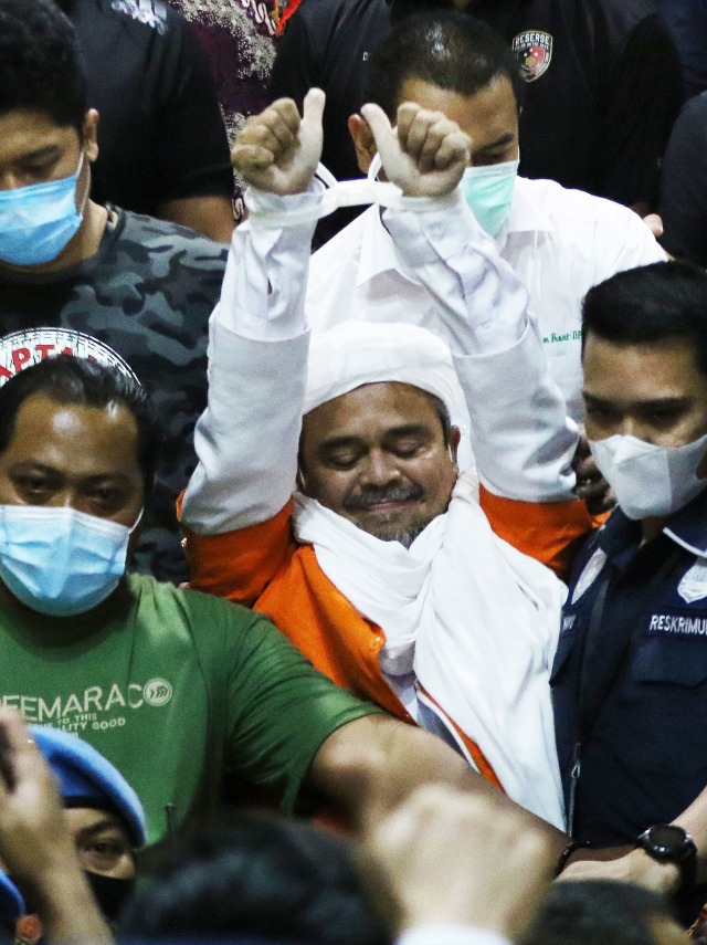 Imam Besar Front Pembela Islam (FPI) Habib Rizieq Shihab (tengah) berjalan menuju mobil tahanan usai diperiksa di Mapolda Metro Jaya, Jakarta, Minggu (13/12/2020) dini hari.
 Foto: Antara/Hafiz Mubarak