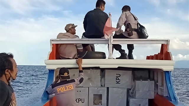 Polisi bersama dengan PPK dan Panwas menggunakan perahu mengangkut kotak suara dan logistik Pilkada Sulut