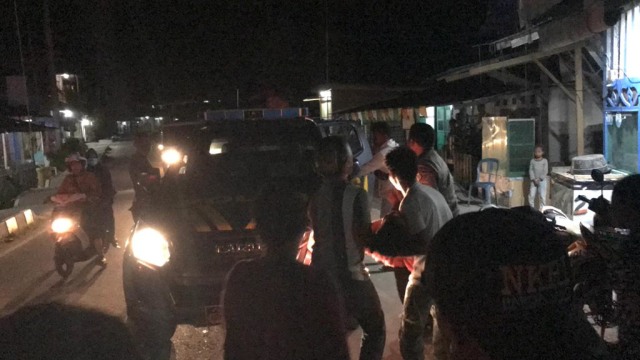 Polisi dibantu warga saat mengangkat korban untuk dibawah ke RSUD Kaimana