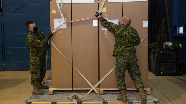 Personel Angkatan Bersenjata Kanada memuat freezer khusus untuk vaksin penyakit coronavirus (COVID-19), menuju wilayah utara, ke palet pesawat dekat Bandara Ottawa di Ottawa, Ontario, Kanada. Foto: CPL MATTHEW TOWER via REUTERS