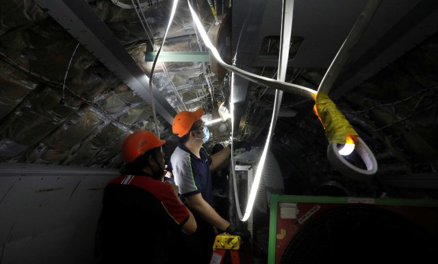 Pekerja menyelesaikan perombakan interior pesawat penumpang Airbus A321 menjadi pesawat kargo di Singapura. Foto: Edgar Su/Reuters