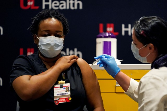 Seorang dokter menyuntikkan vaksin corona kepada perawat di Rumah Sakit Universitas Louisville, Louisville, Kentucky, AS, Senin (14/12).  Foto: Bryan Woolston/REUTERS