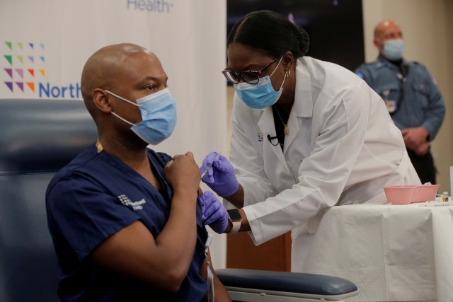 Seorang dokter menyuntikkan vaksin corona kepada perawat di Long Island Jewish Medical Center di New Hyde Park, New York, AS, Senin (14/12).  Foto: Brendan McDermid/REUTERS