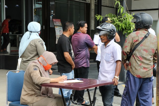 Petugas mencatat pelanggar protokol kesehatan yang terjaring tidak memakai masker pada operasi yustisi di Aceh Barat, Selasa (15/12). Foto: Dok. Humas Aceh Barat