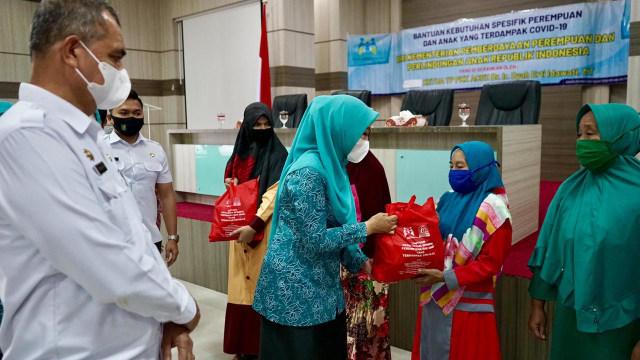 Ketua TP-PKK Aceh, Dyah Erti Idawati, menyerahkan paket bantuan kebutuhan spesifik kepada perempuan dan anak yang rentan terdampak COVID-19 di Sabang, Rabu (16/12). Foto: Abdul Hadi/acehkini 