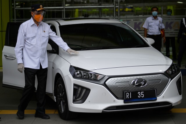 Menteri Perhubungan Budi Karya Sumadi menunjukkan mobil listrik saat diluncurkan sebagai kendaraan dinas Kementerian Perhubungan di Stasiun Gambir, Jakarta, Rabu (16/12). Foto: Sigid Kurniawan/ANTARA FOTO