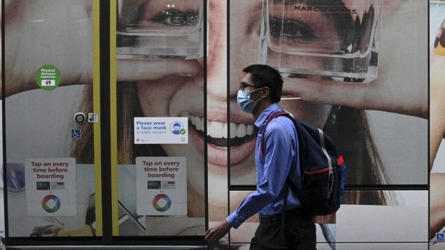 Seseorang memekai masker sedang berjalan di daera Sydney, Australia. Foto: Loren Elliott/Reuters