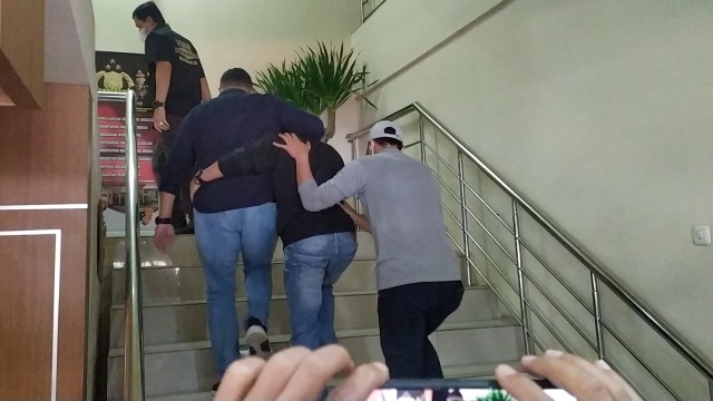 Seorang muncikari yang diamankan di Medan terkait kasus dugaan prostitusi melibatkan artis berinisial TA, tiba di Gedung Ditreskrimum Polda Jabar. Foto: Rachmadi Rasyad/kumparan