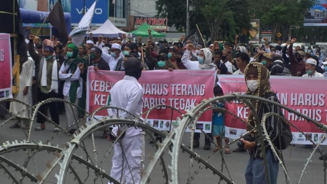 Sejumlah organisasi masyarakat yang mengatasnamakan solidaritas umat Islam Sulawesi tengah di Kota Palu menggelar aksi unjuk rasa di Jalan Samratulangi, Jumat (18/12). Foto: Tim PaluPoso