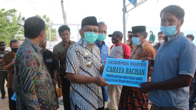Gubernur Sulawesi Barat, Ali Baal Masdar, menyerahkan bantuan perahu sandeq kepada perwakilan kelompok nelayan. Foto: Dok. Istimewa