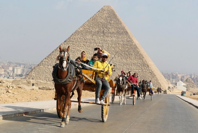 Suasana saat wisatawan mengunjungi Piramida Agung, dataran tinggi piramida Giza di Giza, Mesir. Foto: Mohamed Abd El Ghany/Reuters