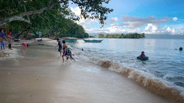Anak-anak tampak bermain ombak di Pantai Luari, Halmahera Utara. Foto: Samsul Hi Laijou/cermat