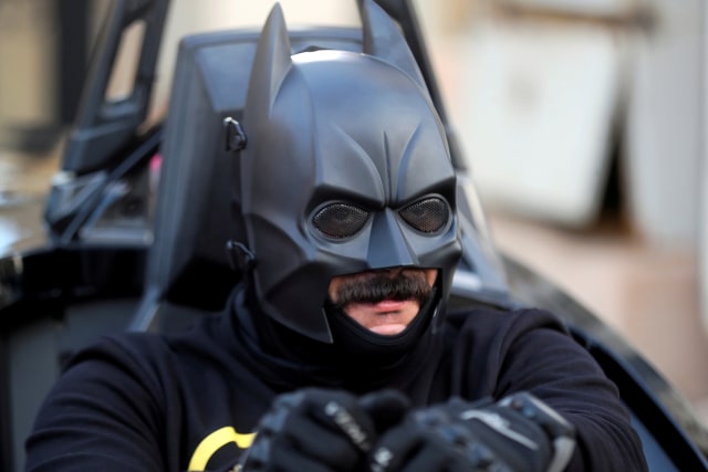 Bassem Raaof, mengenakan kostum Batman mengendarai replika Batmobile di Kairo, Mesir.  Foto: Mohamed Abd El Ghany/REUTERS