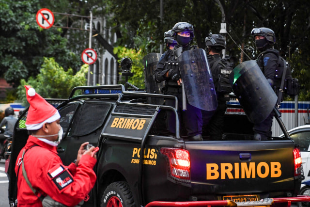 Personel Brimob Polda Metro Jaya melakukan patroli pengamanan di depan Gereja Katedral, Jakarta, Kamis (24/12).  Foto: Hafidz Mubarak A/ANTARA FOTO