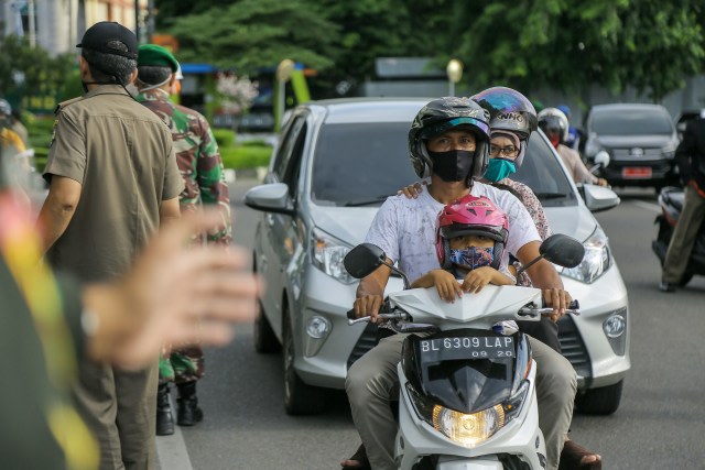 Warga Aceh terlihat mengenakan masker saat melintas di tengah razia protokol kesehatan, Kamis (28/5). Foto: Abdul Hadi/acehkini