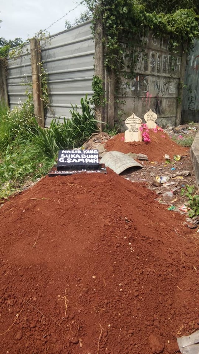 Warga Desa Kemuning, Kecamatan Legok, Tangerang, buat replika kuburan di pinggir jalan demi memberi efek jera atau menanamkan kesadaran kepada orang yang kerap buang sampah sembarangan. (Foto: Facebook/ Aphuk Roup Mcm) 
