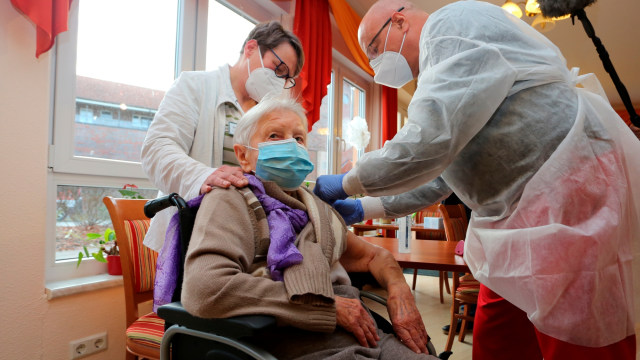 Dokter Bernhard Ellendt  menyuntikkan vaksin COVID-19 kepada penghuni panti jompo Edith Kwoizalla, wanita berusia 101 tahun, di Halberstadt, Jerman, Sabtu (27/12). Foto: Matthias Bein/dpa Via AP