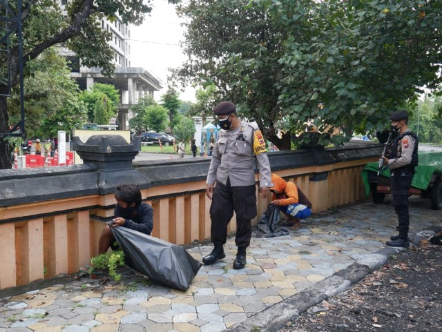 Pelanggar protokol kesehatan memperoleh sanksi membersihkan sampah di perbatasan Kota Solo